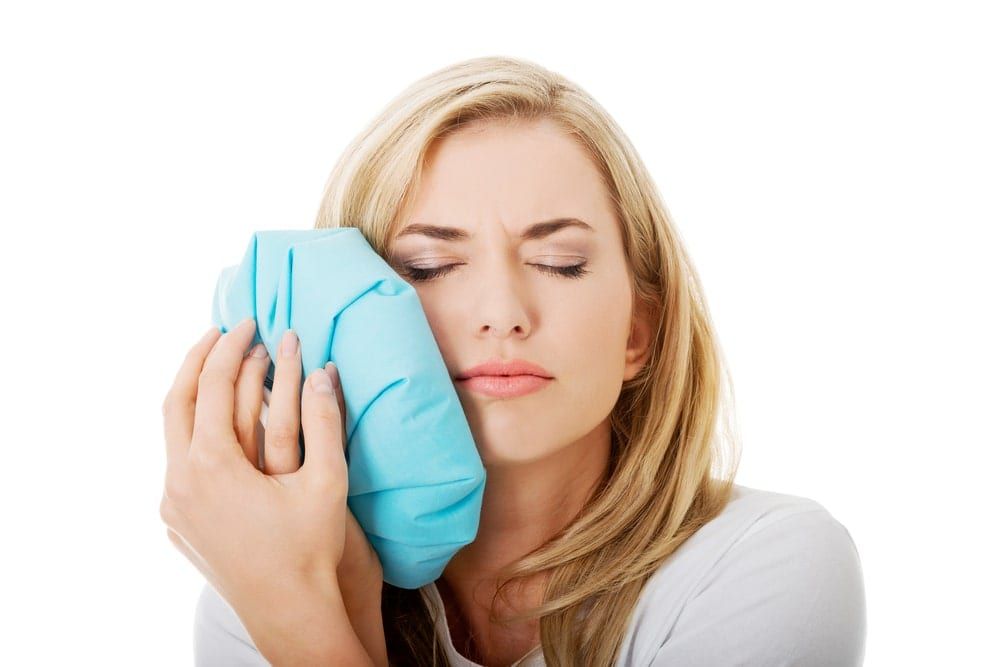 Woman using an ice pack for tooth pain