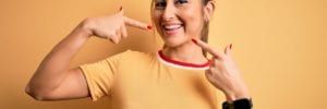 Woman pointing at teeth with fit bit