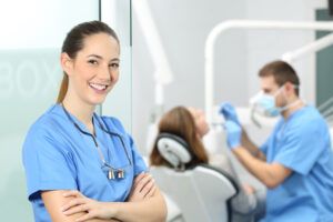 Dental hygienist and dentist with patient